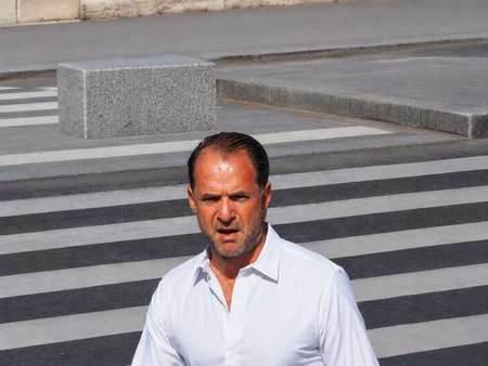 Paris — a man crossing a zebra-striped crosswalk in a white shirt